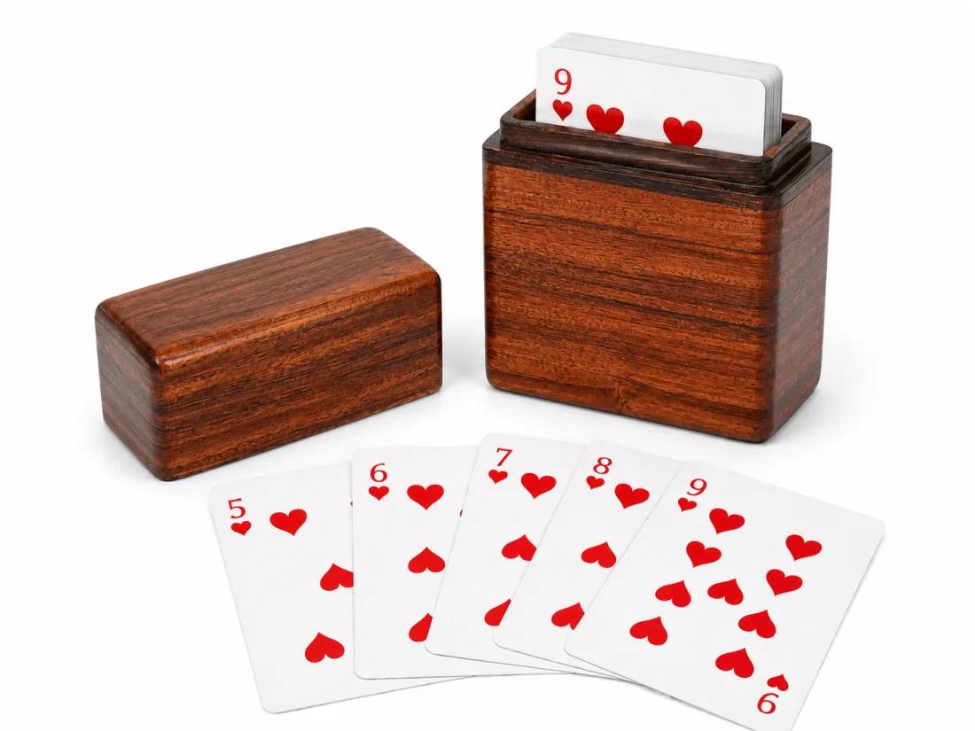 Reddish wooden card box holding a deck, lift-off lid beside it and cards fanned in front
